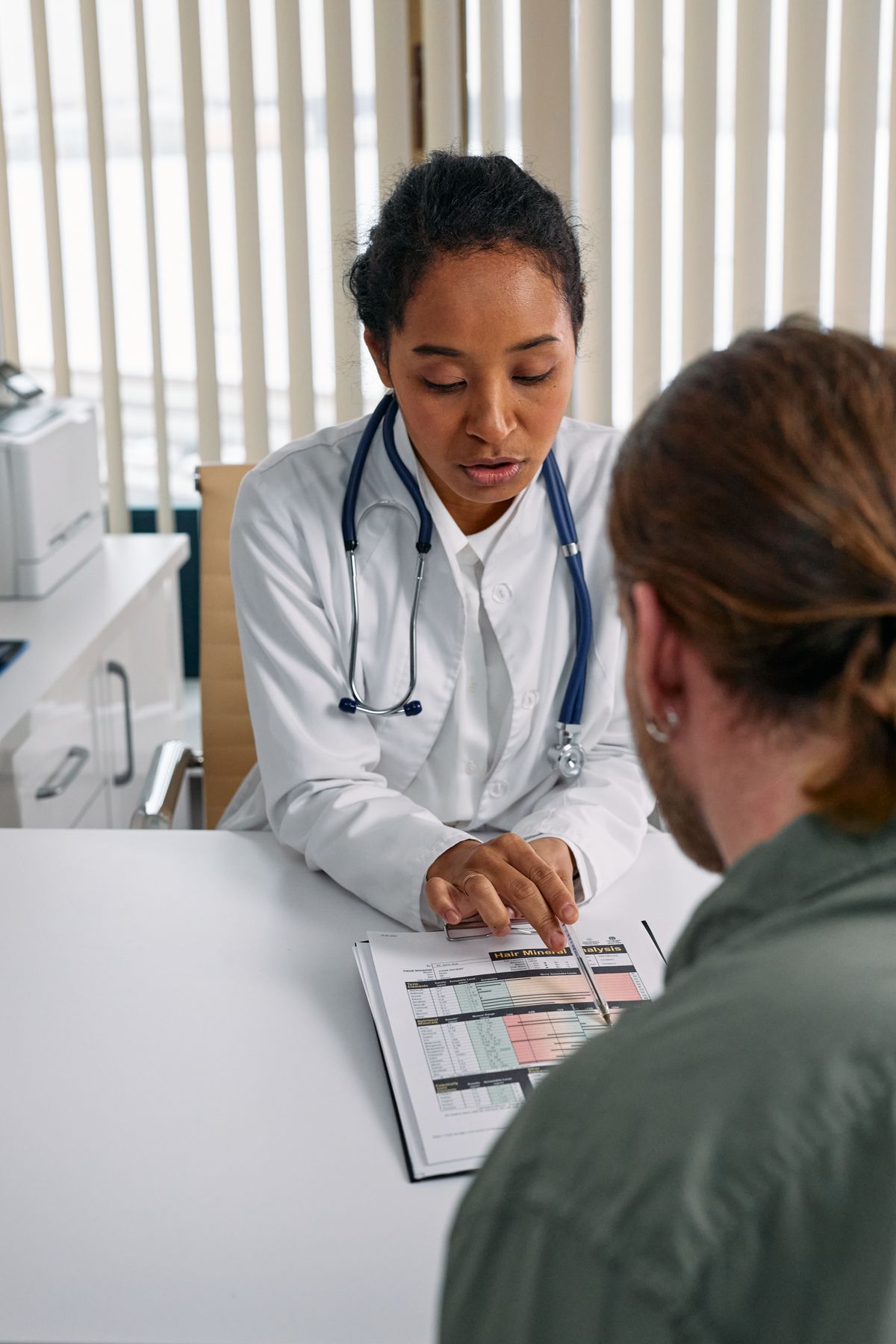 Doctor reviewing a lab results sheet with a patient
