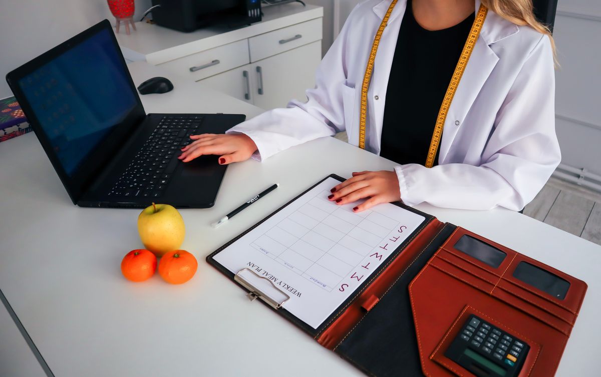 Dietitian reviewing a weekly meal plan with fruit on the desk