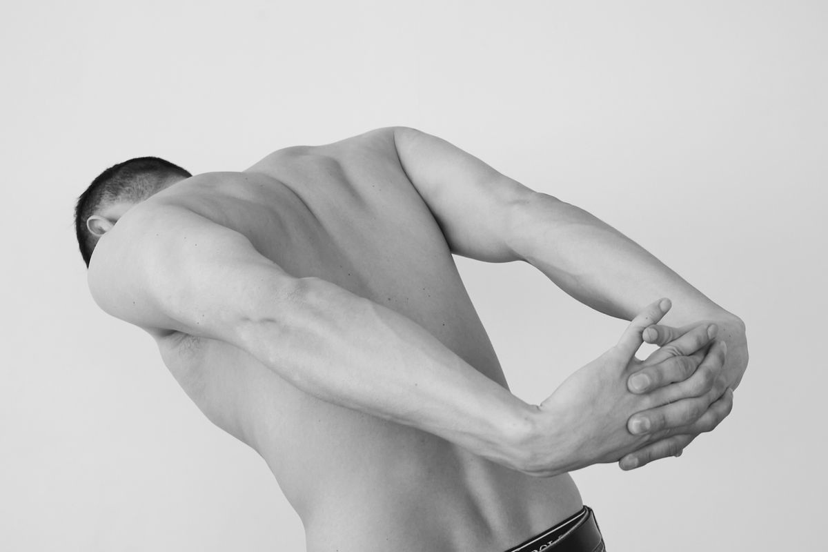 Person stretching their back and shoulder muscles