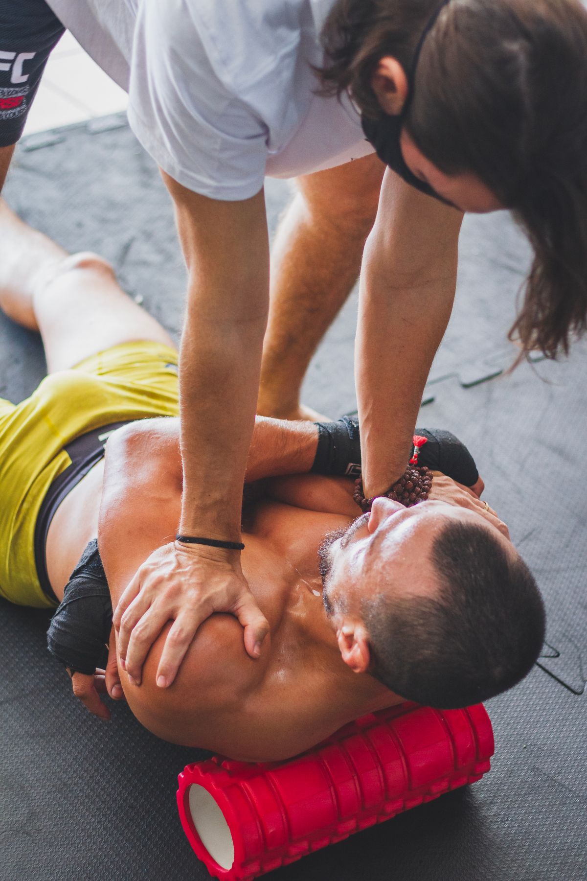 Trainer helping an athlete stretch during a rehabilitation session